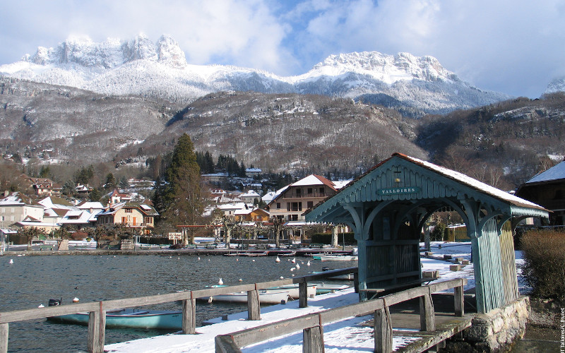 views of the snowy mountains from lake annecy
